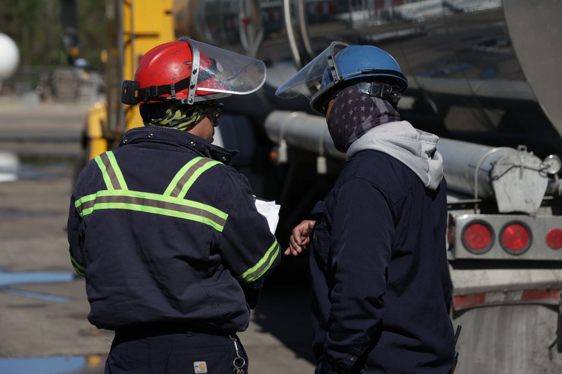 Element operators reviewing paperwork beside a bulk transport trailer at the Cleveland facility